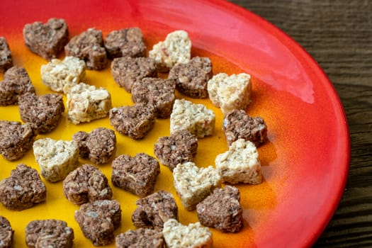 Plate with heart shaped cookies on wooden table