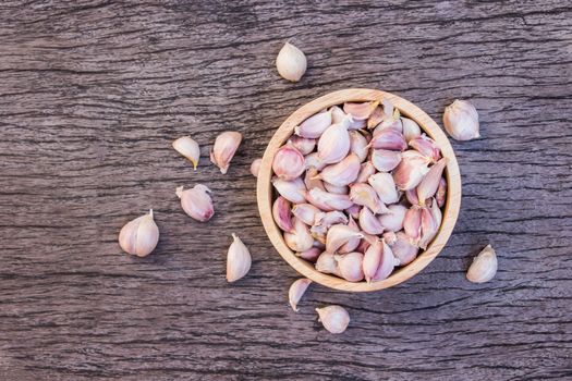 Dry garlic put in wood bowl on old wooden background. Top view