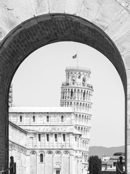Leaning Tower in Pisa, Torre pendente di Pisa. View through arch of New Gate, Porta Nuova. Tuscany, Italy, UNESCO World Heritage Site. Black and white image.