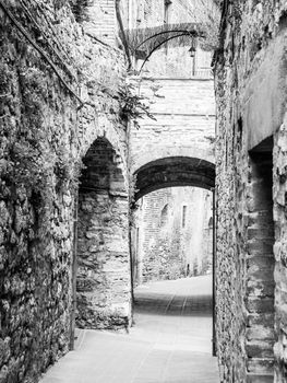 Picturesque medieval narrow street of San Gimignano old town, Tuscany, Italy. Black and white image.