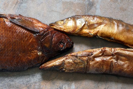 Closeup of few freshness smoked fishes on stone background