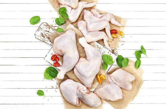 Raw chicken meat on cutting board on a white wooden background. Top view. Copy space