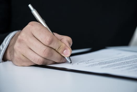 Businessman signing a contract close up view from behind