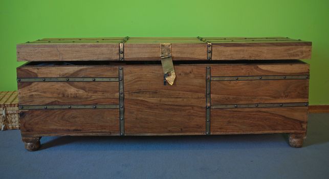 Brown vintage wooden chest with green and blue background
