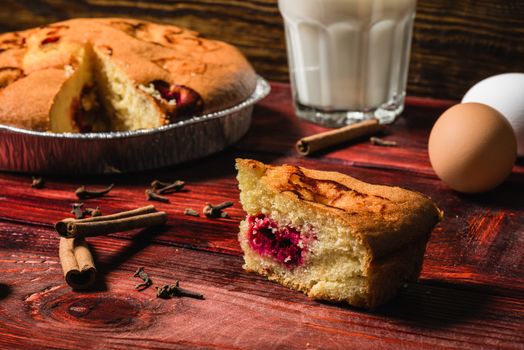 Sweet breakfast with cherry pie and milk. Some ingredients lie on the table.