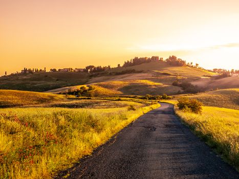 Evening landscape of Tuscany with curvy aspalt road, Italy.