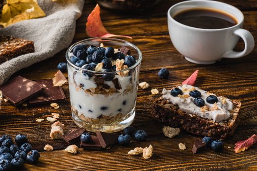Granola with Yogurt, Blueberries, Honey and Chocolate Bars and Blueberry Toast with Cup of Coffee