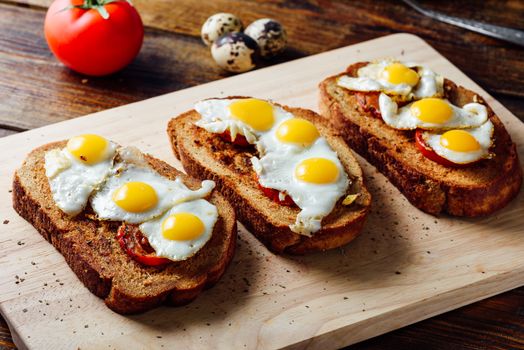 Three Bruschettas with Fried Quail Eggs and Tomatoes