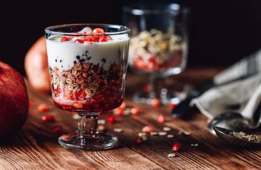 Pomegranate Parfait with Some Ingredients on Backdrop. Series on Prepare Healthy Dessert with Pomegranate, Granola, Cream and Jam.