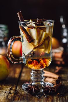 Hot Spiced Beverage with Sliced Apples and Different Condiment.