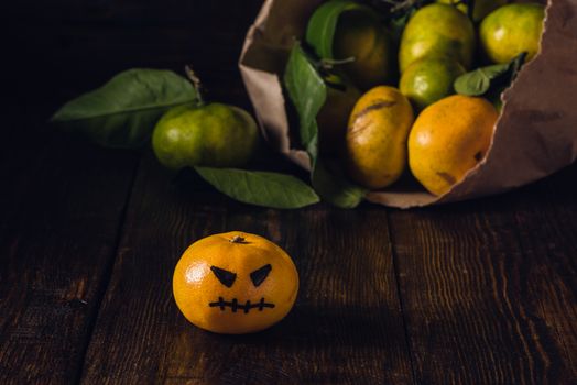 Scary tangerines for Halloween and bunch of tangerines on background