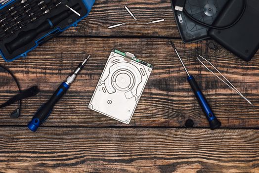 HDD with Professional Precision Screwdriver and Some Tools on Wooden Table