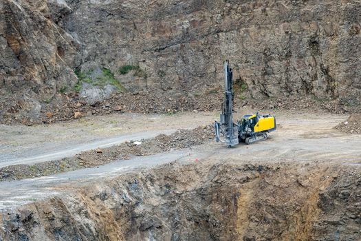 Opencast mining quarry with mining drilling machine. Mining in the granite quarry. Mining industry.