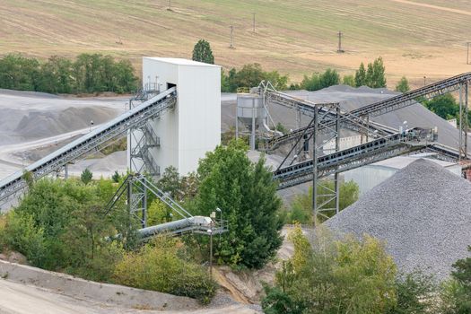 Mining quarry with machinery. Belt conveyors and mining equipment in a quarry.
Stone quarry with silos, conveyor belts and piles of stones. Quarrying of stones for construction works.