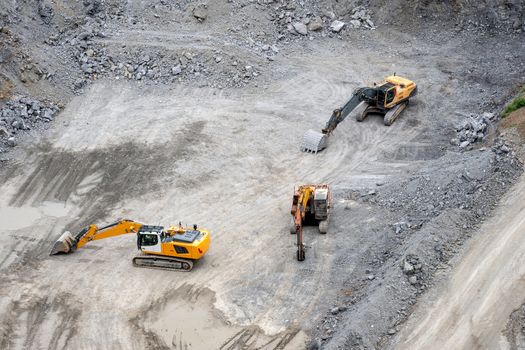 Mining in the granite quarry. Working mining machine - digger. Mining industry.