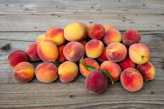 Pile of peaches. Ripe peaches fruit on a brown wooden background.