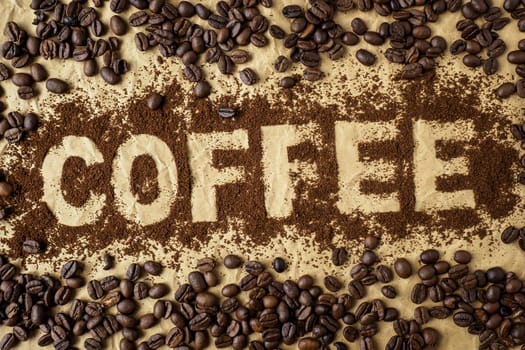 Roasted coffee beans on brown wrapping paper. The word "coffee"