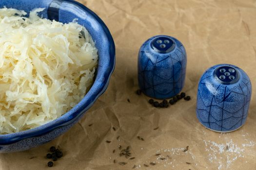 Blue bowl of sauerkraut (pickled white cabbage). Fermented cabbage.