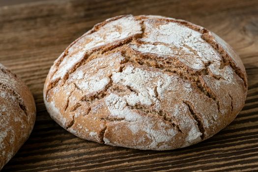 Delicious baked bread on a wooden background