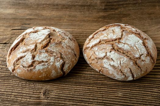 Delicious baked bread on a wooden background