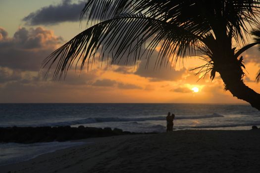 Romantic couple at beach with sunset in the background at Barbados island