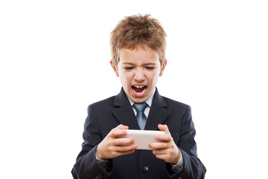 Little handsome smiling child boy in business suit playing games or surfing internet on digital smartphone computer white isolated