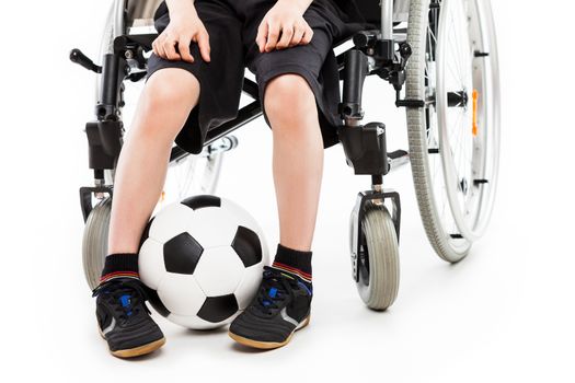 Invalid or disabled child boy sitting on wheelchair hand holding soccer sport ball white isolated