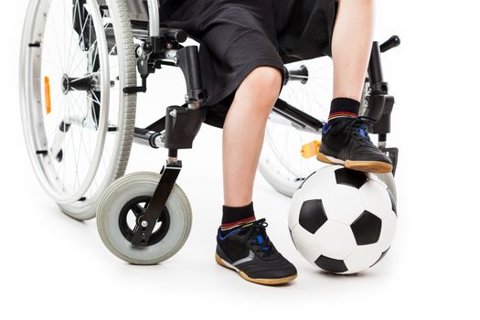 Invalid or disabled child boy sitting on wheelchair hand holding soccer sport ball white isolated