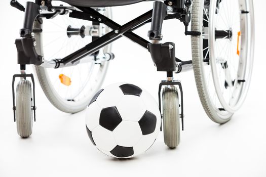 Wheelchair for invalid or disabled person and soccer ball white isolated