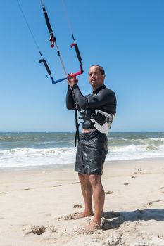 Kiteboarder preparations for surfing on a sunny day.