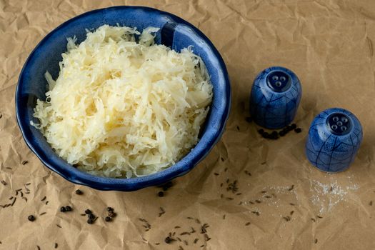 Blue bowl of sauerkraut (pickled white cabbage). Fermented cabbage.