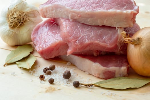 Fresh pork with ingredients for cooking on wooden board