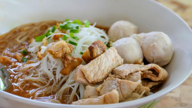 close up asian noodles soup with pork meatball and vegetables