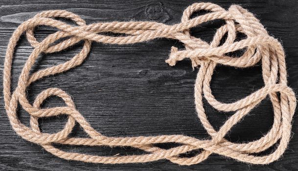 old rope closeup on black wooden background