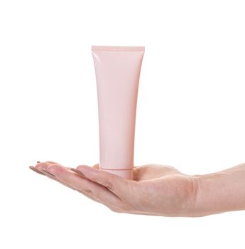 Female hand with a tube of cosmetic cream on white isolated background