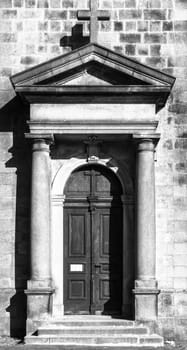 Old wooden church door. Entrance to the St Peter and Paul Church in Tanvald, Czech Republic. Black and white image.