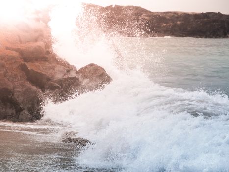 Water splash of breaking wave on the rocky shore.