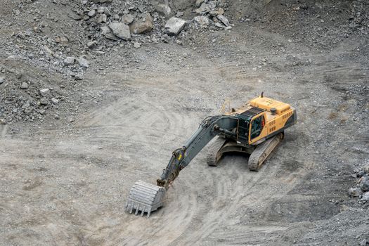 Mining in the granite quarry. Working mining machine - digger. Mining industry.