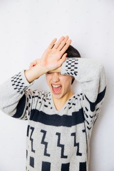 Portrait of young upset and stressed woman standing near the wall with headache and lot of problems.