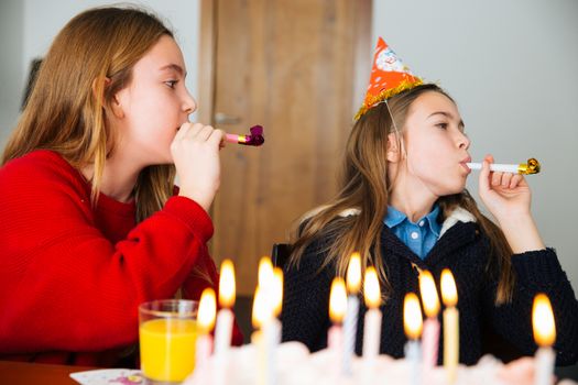 Group of kids celebrate birthday together and blowing in the whistles