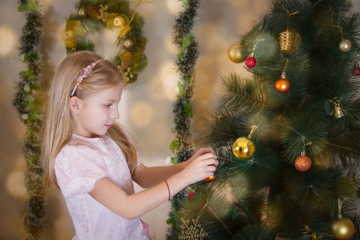 Cute girl decorating Christmas tree with balls