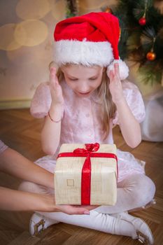 Child baby girl receiving Christmas miracle, magic gift box