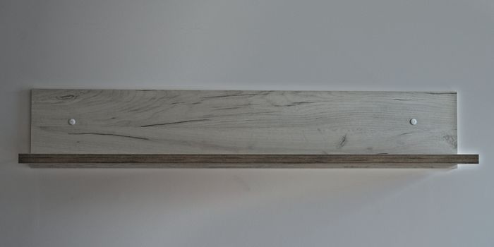 Empty gray wooden shelf on white wall, front view