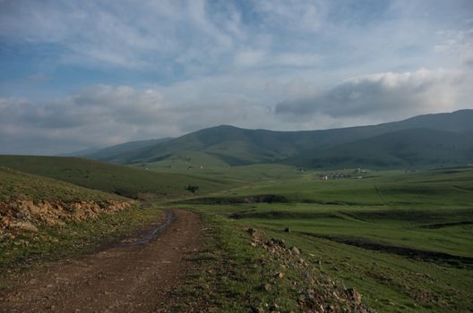 Spring landscape in sunset with clouds, hills and meadow. Zlatibor mountain area, Serbia