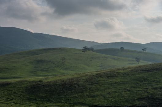 Spring landscape in sunset with clouds, hills and meadow. Zlatibor mountain area, Serbia