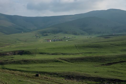 Spring landscape in sunset with clouds, hills and meadow. Zlatibor mountain area, Serbia