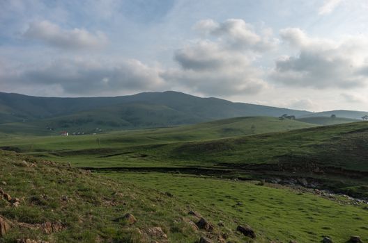 Spring landscape in sunset with clouds, hills and meadow. Zlatibor mountain area, Serbia