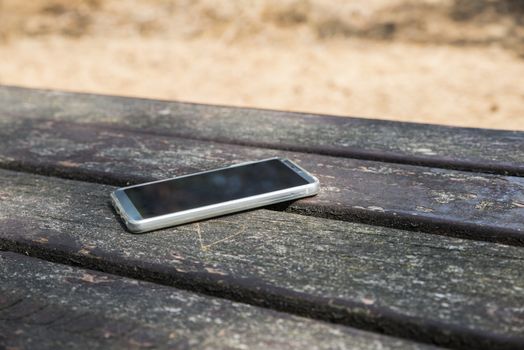 mobile phone lost on a table in the wood
