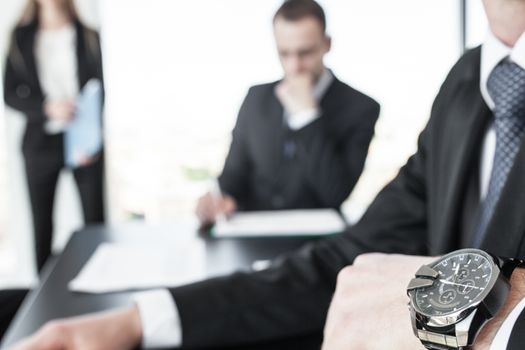 Time is money, business people in office, close up of man hand in wristwatch