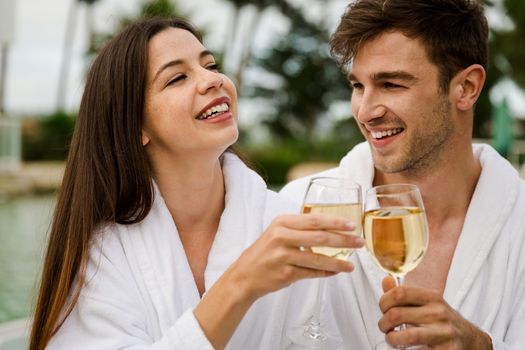 Young couple  in a luxury hotel tasting a glass of white wine